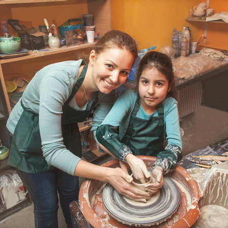 Mother and daughter mold with clay, pottery children, smileの写真素材