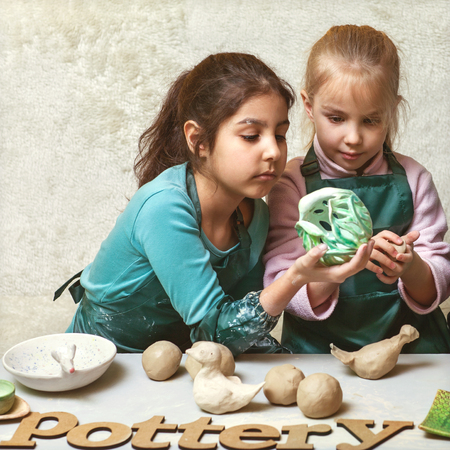 Little girls with clay, pottery childrenの写真素材