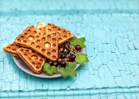 Belgian waffles with currant isolated on a blue backgroundの写真素材