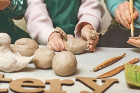 Girls and mother teen potter clay bowl working in pottery workshop traditional Arts. The inscription on the pottery tableの写真素材