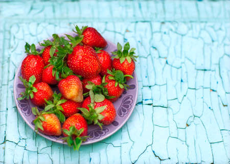 strawberries on the plate lies on a wooden backgroundの写真素材