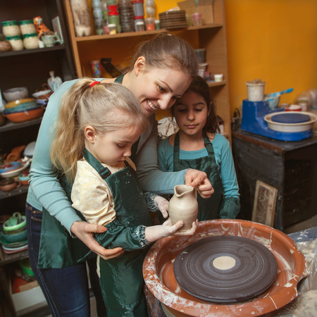 Mother and daughters mold with clay, pottery childrenの写真素材