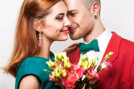 Portrait of a young couple in love. The guy gives her flowers, the concept of Valentine's Dayの写真素材