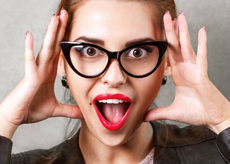 hipster fashion girl in studio near brown background smiling and waving his hands emotionally. Vogue Styleの写真素材