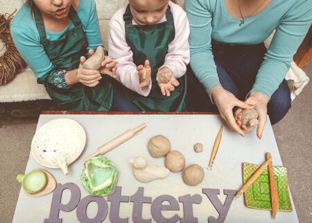 Girls and mother teen potter clay bowl working in pottery workshop traditional Arts. The inscription on the pottery tableの写真素材