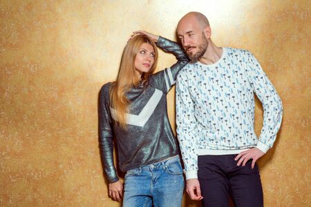 fashion hipster couple in love posing on a gold background. The concept of St. Valentine's Day.