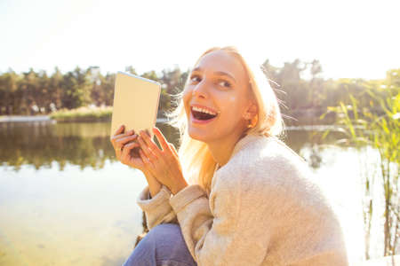 girl in an autumn park near a lakeの写真素材