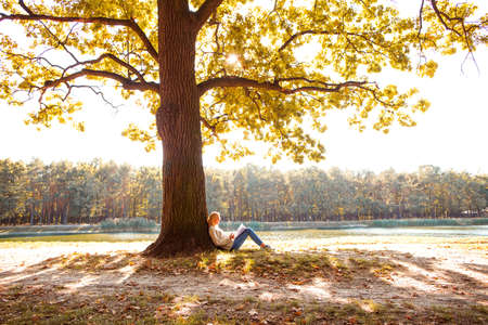 girl in an autumn park near a lakeの写真素材