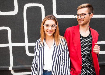 Fashion shopping in sunglasses posing, smiling happily and surprised. They are dressed in striped clothes. Vogue Styleの写真素材