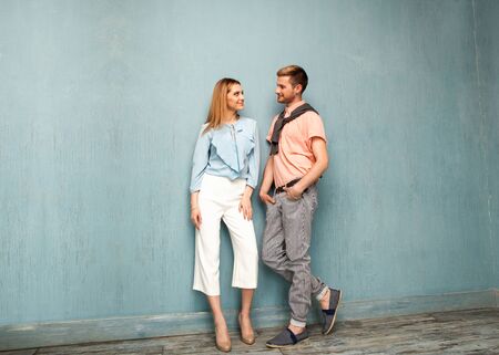 Fashion girl and guy in outdoor clothes posing on a blue backgroundの写真素材