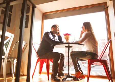 guy with a girl in a cafe on St. Valentine's Day, a guy gives a bouquet of flowers.の写真素材
