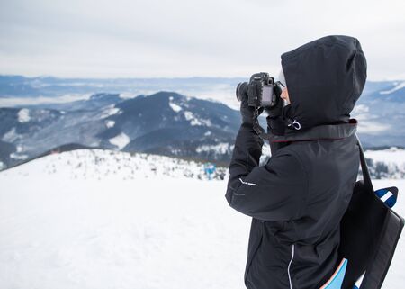 photographer in the winter, on top of the mountainの写真素材