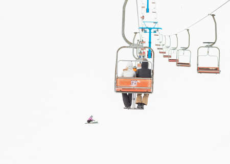 two skiers on a platform on a background of high snow mountainsの写真素材