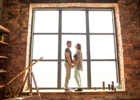 Couple in love pregnant cuddling, waiting for babyの写真素材
