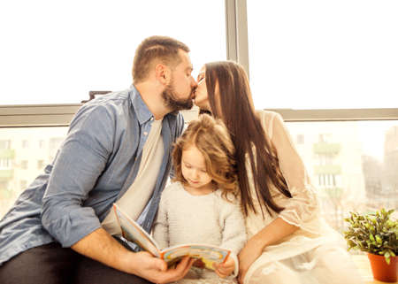 happy family reading a book to her daughter. Mothers Day.の写真素材