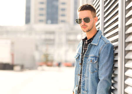 fashion guy posing in sunglasses on sunsetの写真素材