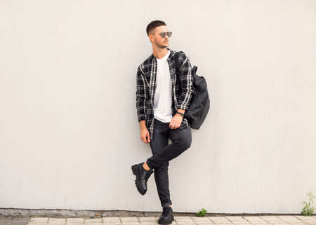 Fashion guy posing in sunglasses on sunsetの写真素材