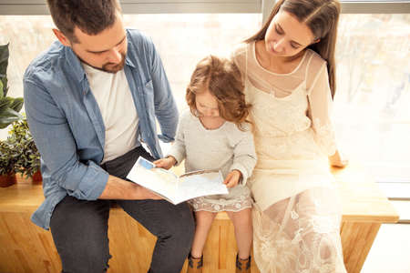 happy family reading a book to her daughter. Mothers Day.の写真素材