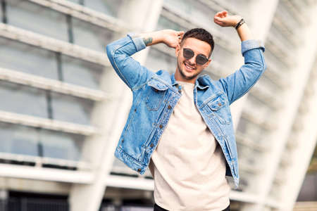 fashion guy posing in sunglasses on sunsetの写真素材