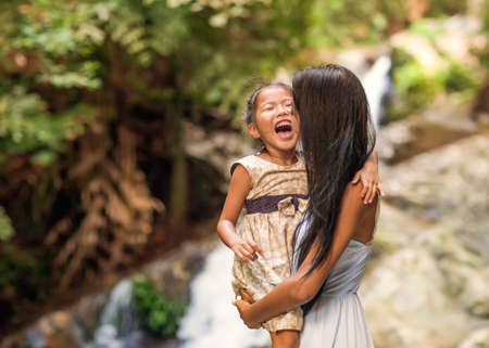 happy mother with her daughter in the tropics near the waterfall. Mothers day.の写真素材