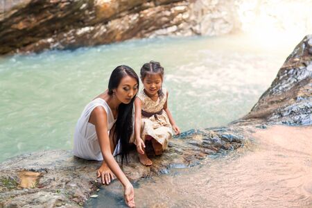 happy mother with her daughter in the tropics near the waterfall. Mothers day.