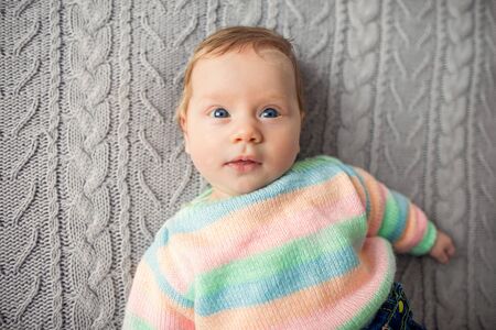baby is lying on the bedの写真素材