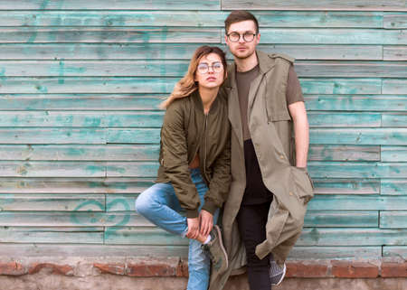 fashion couple standing posing near blue wooden wallの写真素材