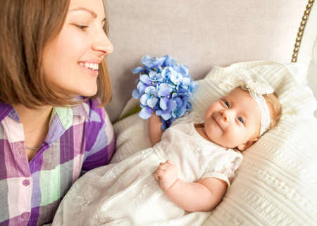 baby with your mothers is lying on the bed, mother's day concept.