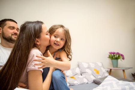 happy family playing with her daughter at homeの写真素材