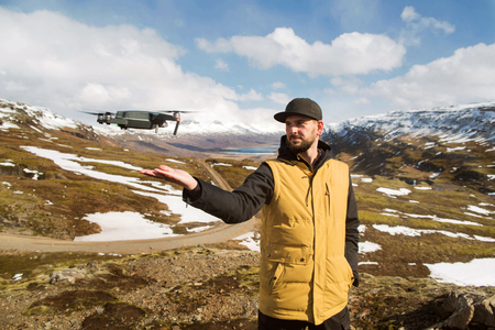 guy tourist launches quadrocopter with hands in the mountains