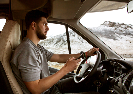 guy tourist driving a car in the mountains, traveling to Iceland.