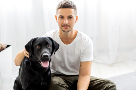 guy freelancer with his dog labrador playing at homeの写真素材