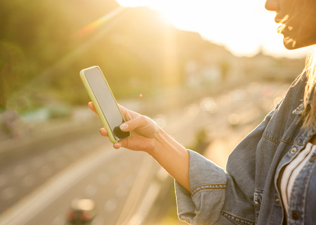 girl freelancer at sunset speaks on the phone and worksの写真素材