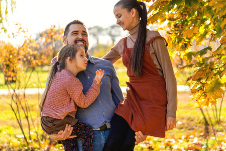 family walking in autumn park at sunsetの写真素材