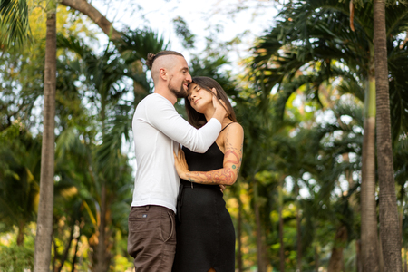 Couple in love laughing looking at each other in the Bangkok park  and tropical threesの写真素材
