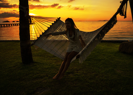 girl in a hammock bother palm trees enjoying a tropical vacationの写真素材