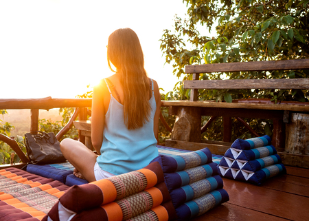 girl watching the sunset meditatingの写真素材
