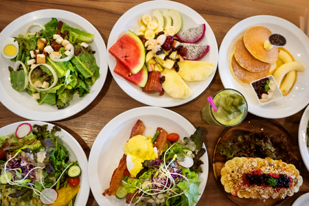 plates with dishes. stand on steel, salads, desserts and fruitsの写真素材
