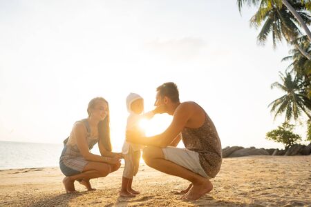 Happy family playing at sunsetの写真素材
