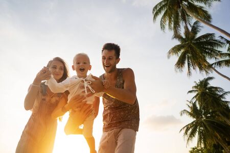 happy family playing at sunsetの写真素材