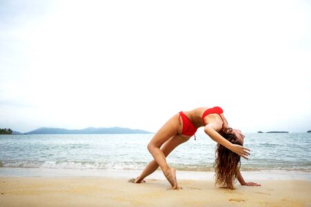 girl doing yoga on the beachの写真素材