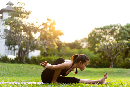 girl doing yoga at sunset in Thailand in the parkの写真素材