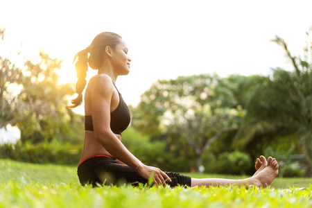 girl doing yoga at sunset in Thailand in the parkの写真素材