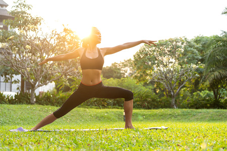 girl doing yoga at sunset in Thailand in the parkの写真素材