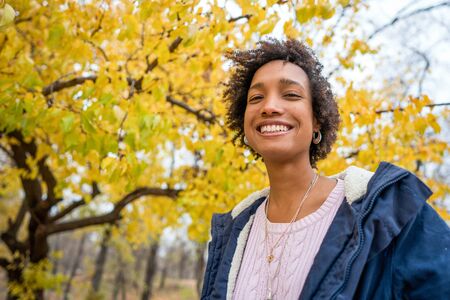 beautiful african girl in autumn park outdoors smilingの写真素材