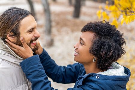 guy with an african american girl in love in autumn park walk at sunsetの写真素材