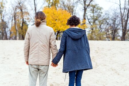 guy with an african american girl in love in autumn park walk at sunsetの写真素材