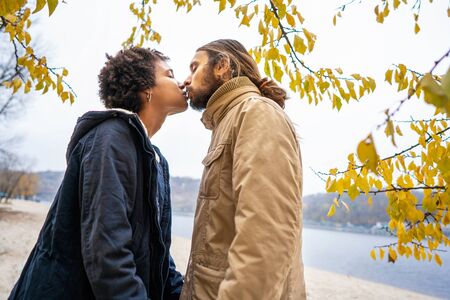guy with an african american girl in love in autumn park walk at sunsetの写真素材