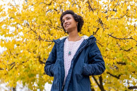 afro girl in autumn park outdoors smilingの写真素材
