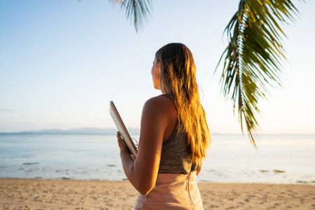freelancer girl with a computer among tropical palm trees work on the islandの写真素材